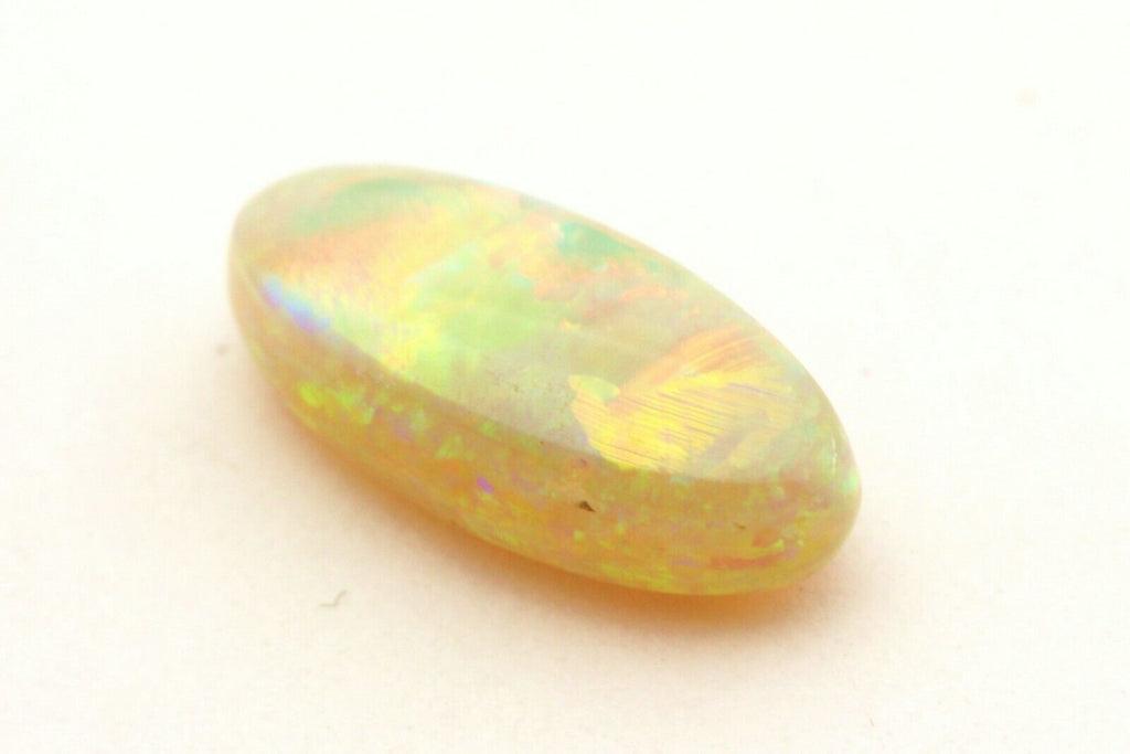 loose natural white opal 2.01ct 12.50x5.60x4.15mm oval cabochon w/ play of color